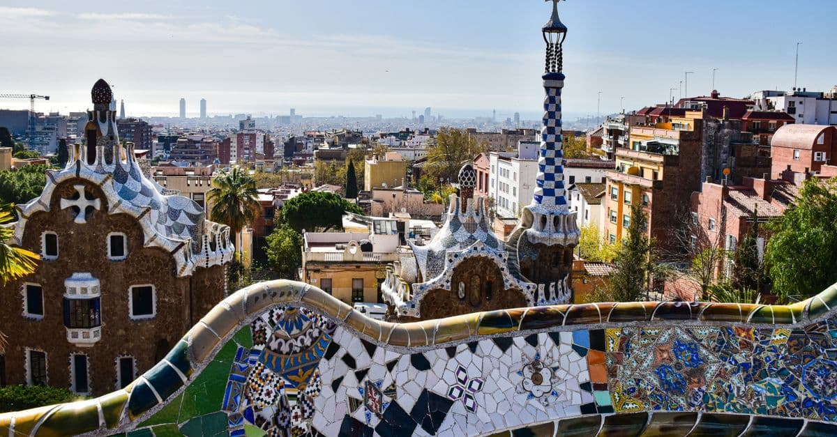 Gaudí's colourful mosaic architecture at Park Güell overlooking Barcelona's sweeping cityscape.