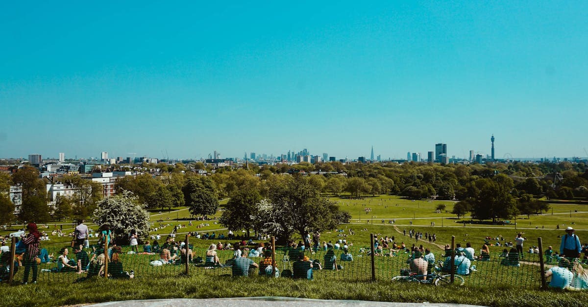 View from Primrose Hill with people relaxing and the London skyline, ideal for UK short breaks