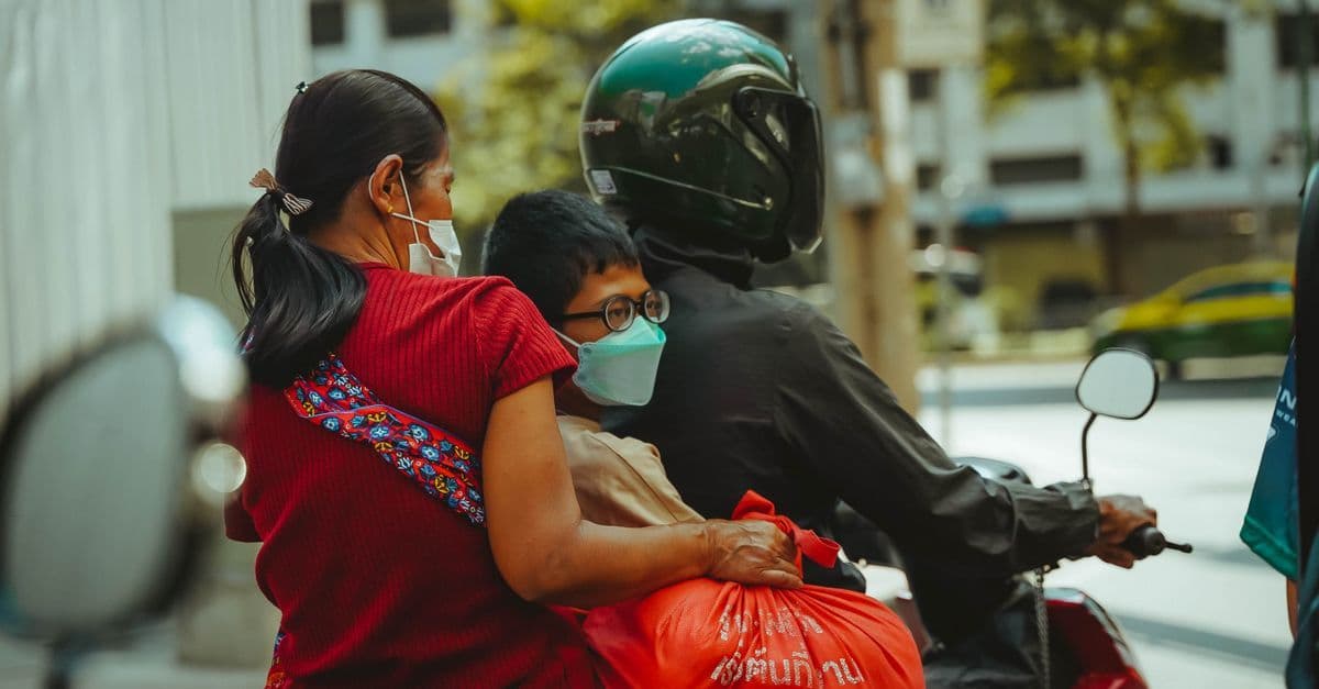 Gezin op een scooter door Bangkok — een praktisch voorbeeld van lokaal vervoer bij reisadvies thailand over vaccinaties en verzekeringen.