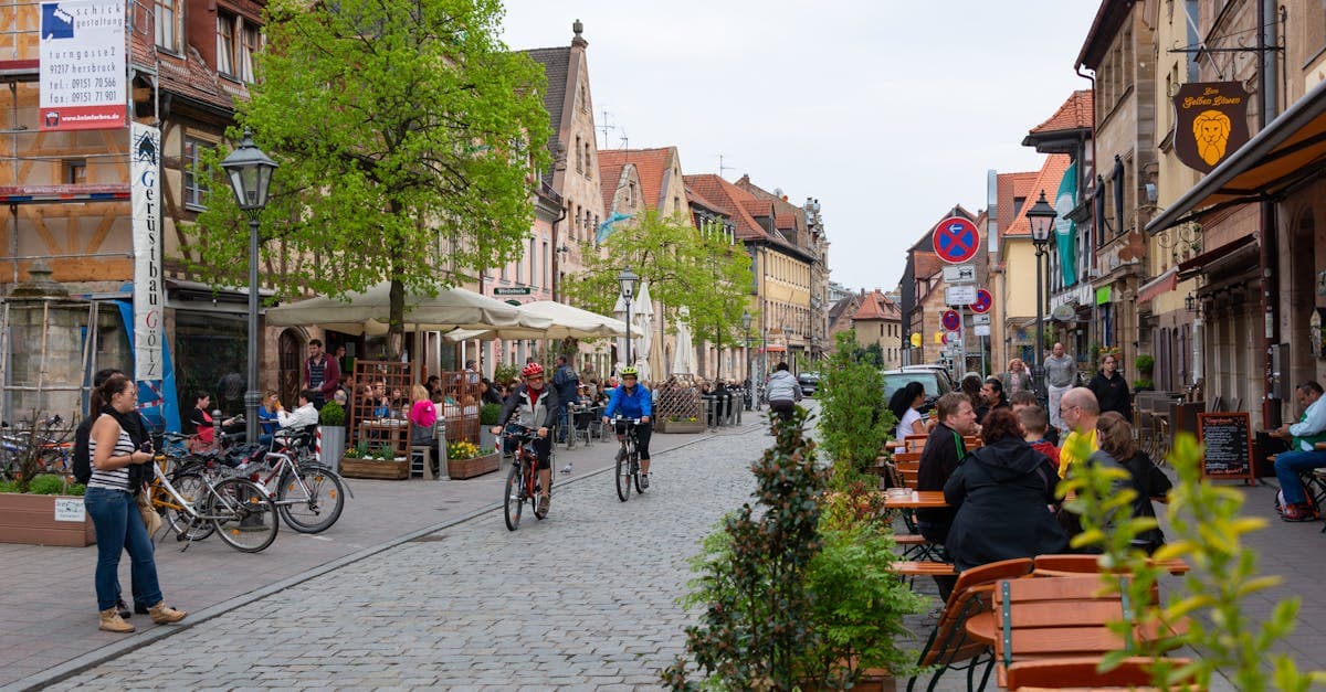 Radfahrer und Besucher genießen ein Straßencafé in der historischen Altstadt von Fürth, Bayern