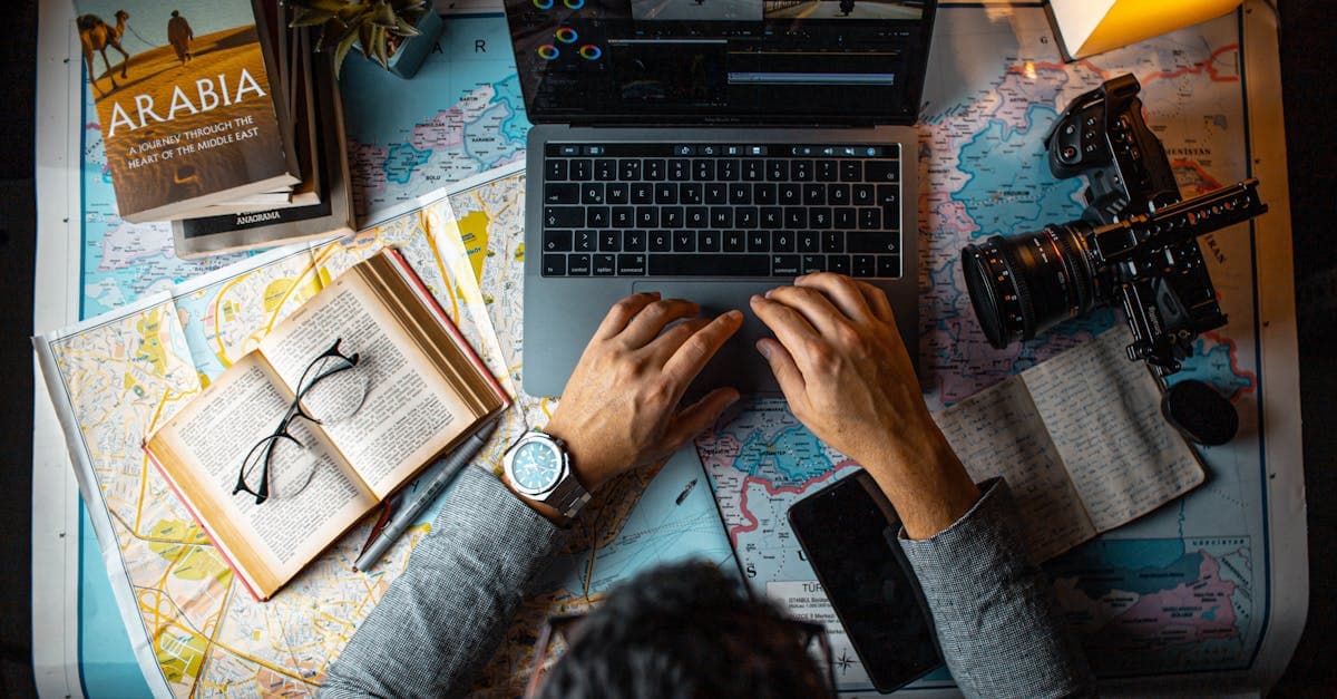 Traveller planning a budget digital travel eSIM itinerary using a laptop and maps at a desk.