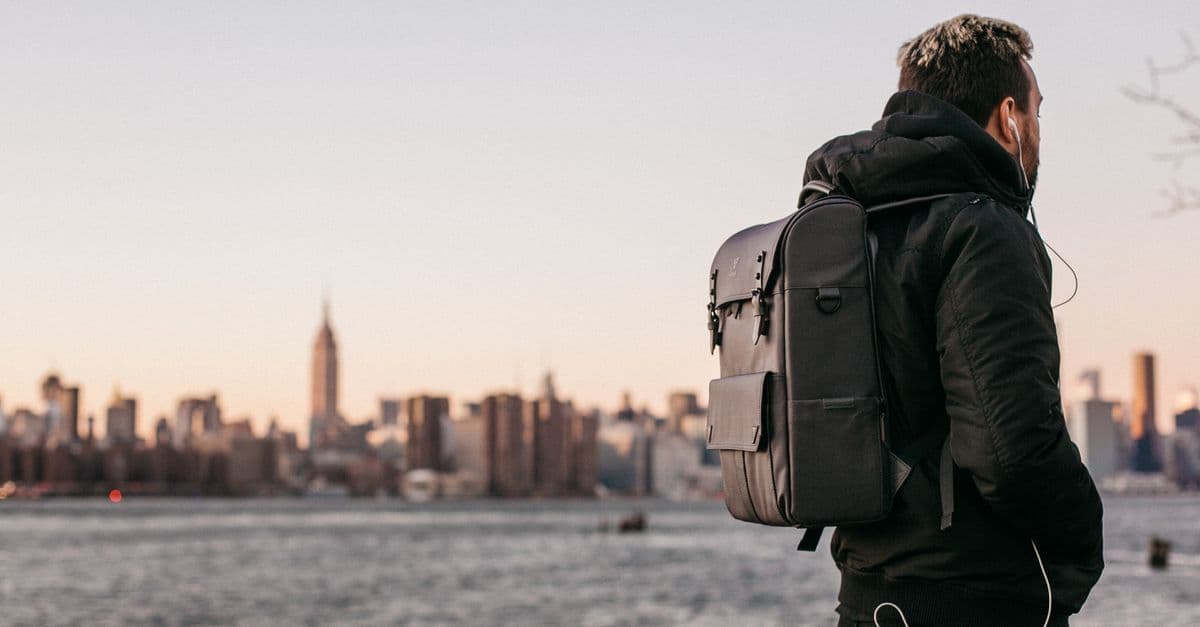Un viajero con mochila mira los rascacielos de Manhattan desde la orilla de Brooklyn, en Nueva York.