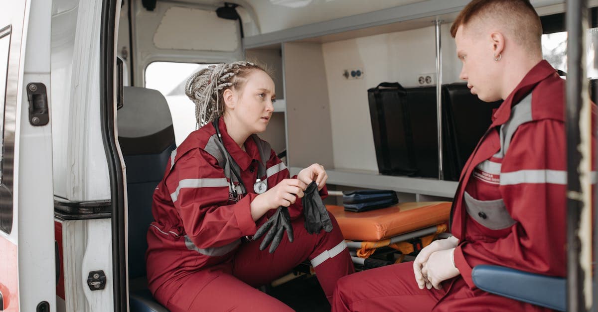 Two paramedics preparing emergency medical equipment inside an ambulance, crucial during a travel health crisis.