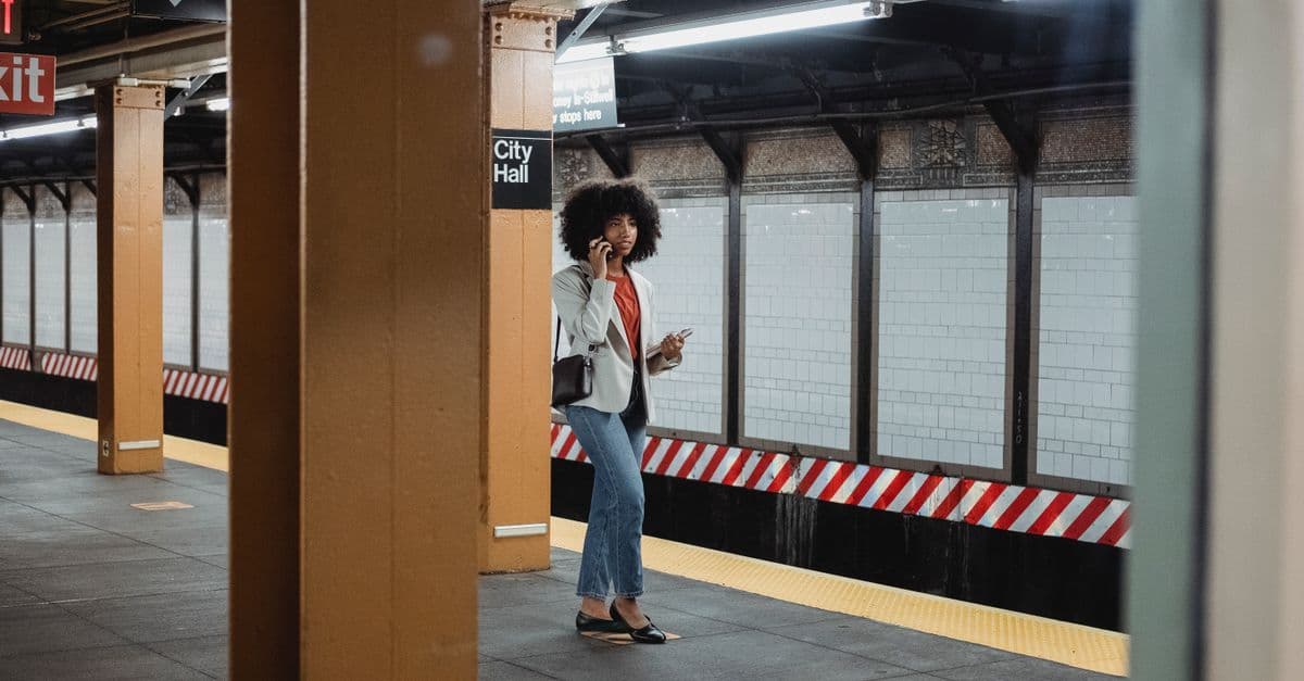 Una donna parla al telefono sulla banchina della stazione City Hall della metropolitana di New York.