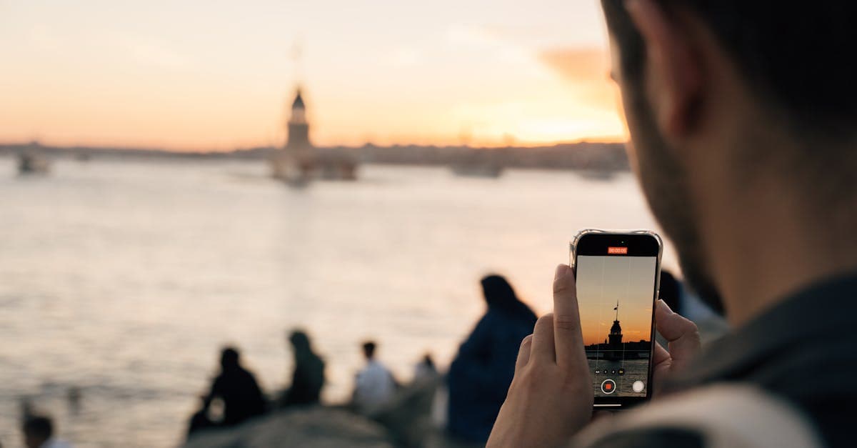 Gün batımında deniz kenarındaki kuleyi akıllı telefonuyla fotoğraflayan kişi, roaming kapalıyken internet erişimini değerlendiriyor