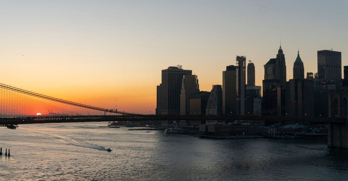 Vista deslumbrante do Brooklyn Bridge e skyline de Manhattan ao pôr do sol no calor de julho em Nova York
