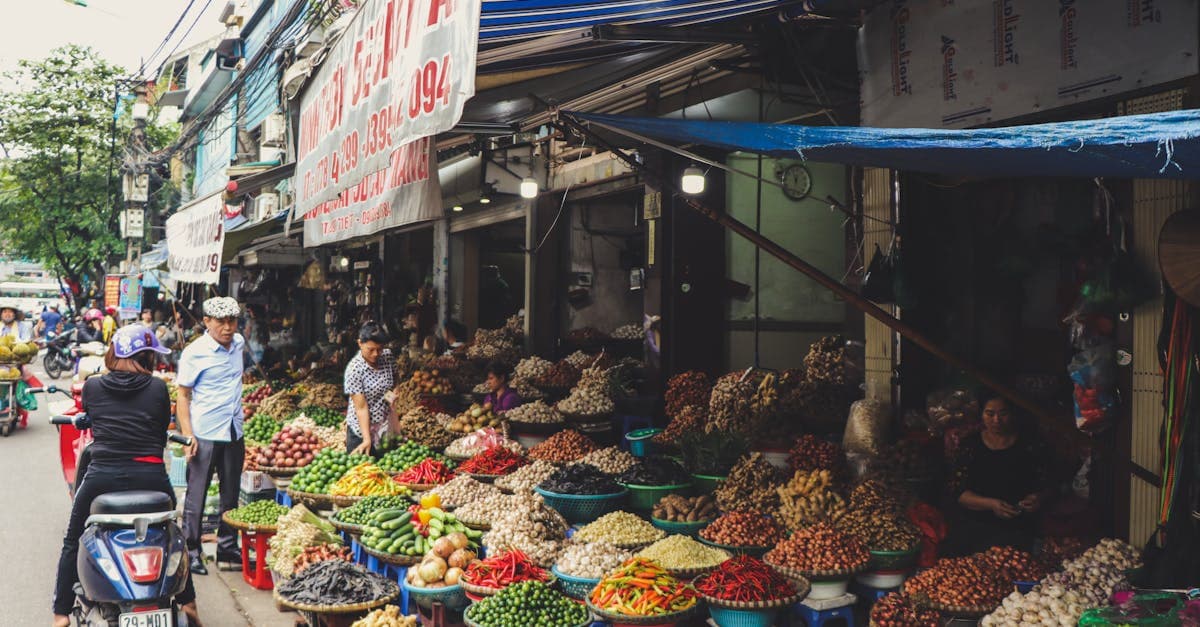 Travende gademarked i Hanoi med farverige grøntsager og lokale sælgere med hanoi alley street food