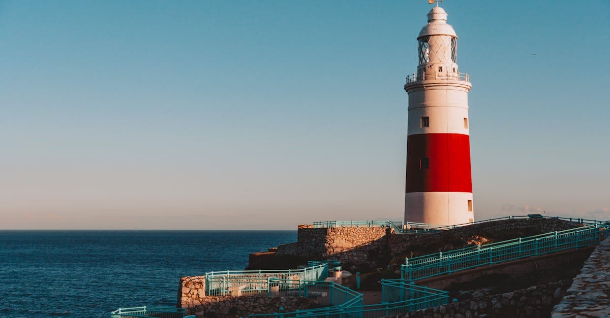 Faro de Europa Point en Gibraltar sobre el mar azul al atardecer, inspiración para viajar barato europa