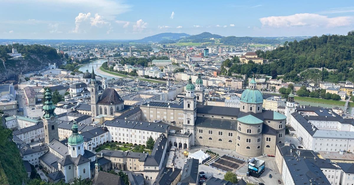 Beeindruckende Luftaufnahme der historischen Altstadt von Salzburg mit den Alpen im Hintergrund.