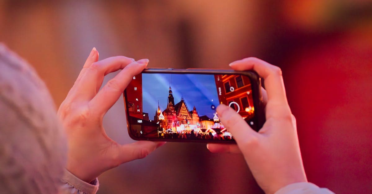 A smartphone captures Wrocław's festive market square with a vibrant evening glow.