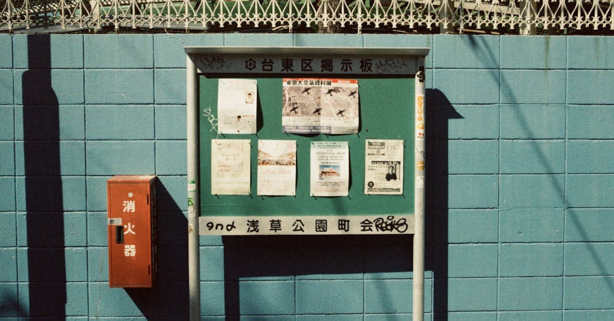 Vintage notice board covered in posted papers on a blue brick wall in Tokyo, Japan.
