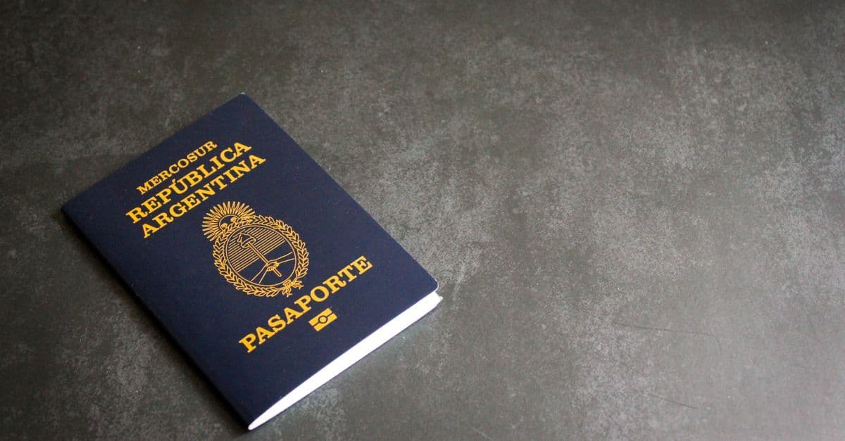 Passaporte argentino sobre fundo escuro ilustrando dúvidas frequentes sobre o working holiday visa