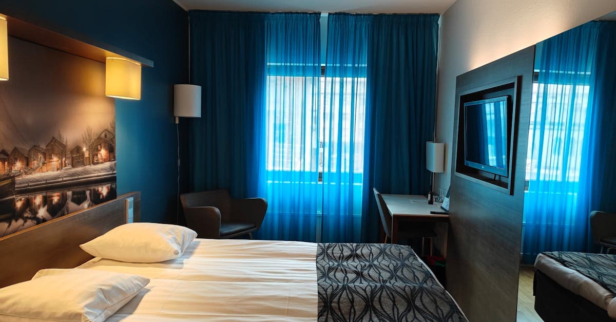 Tyylikäs hotellihuone sinisillä verhoilla – yksi vaihtoehdoista Clarion Hotel Helsinki Airportin lähettyvillä.