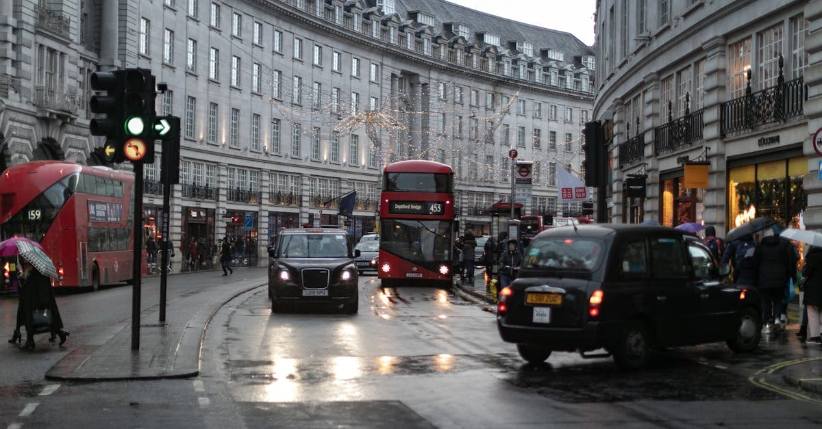 Double-decker buses and taxis navigating rainy Piccadilly Circus, illustrating london weather rainfall compared to Canadian cities