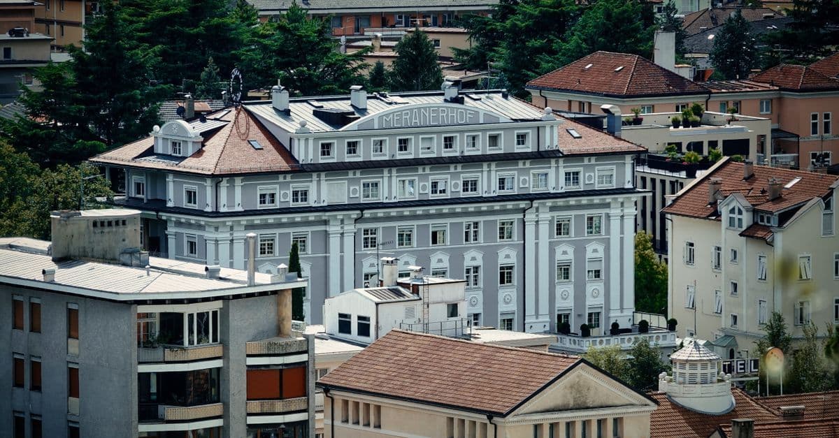 Hall elegante di un hotel family trentino con architettura tradizionale alpina, accogliente per famiglie con bambini.