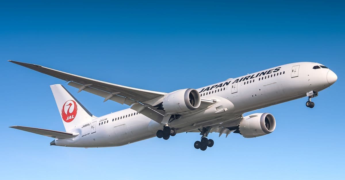 Japan Airlines Boeing 787 Dreamliner in clear skies, a top choice for direct flights to Japan from UK.