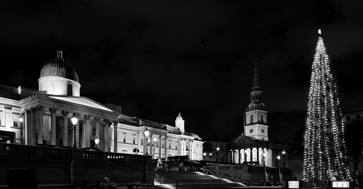 Trafalgar Square de noche con la National Gallery y luces navideñas que iluminan la plaza.