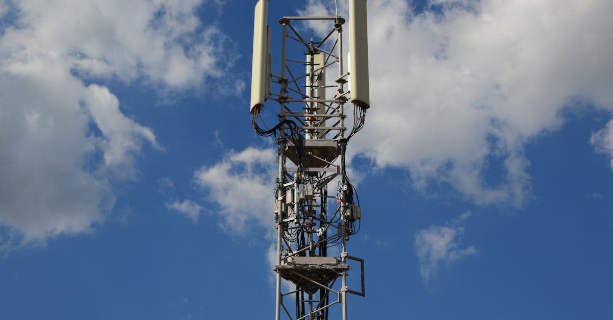 Høj mobilmast mod blå himmel symboliserer 5G-netværk til hurtig bærbar wifi
