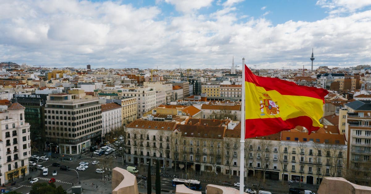 US tax forms representing Beckham Law and foreign earned income exclusion benefits for digital travel eSIMs in Spain
Spain's standard income tax tops out at 47%. The Beckham Law cuts that to a flat 24% on Spanish income up to €600,000 per year, a regime available to workers who relocated to Spain for professional reasons, including digital nomad visa holders.
The formal name is Régimen Especial para Trabajadores Desplazados, and it isn't automatic. DNV holders must file Form 149 with Spain's Agencia Tributaria within 6 months of registering with Spanish Social Security. Miss that window and you default to progressive rates running from 19% up to that 47% ceiling. The clock starts at Social Security registration, not visa approval, which is what catches most nomads off guard.
The US complicates the picture in a way no other nationality faces quite the same way. The US taxes its citizens on worldwide income regardless of where they live. The primary offset tool is the Foreign Earned Income Exclusion (FEIE): US citizens who satisfy the Physical Presence Test (330 days outside the US within any 12-month period) can exclude roughly $126,500 of foreign earned income from federal tax, based on the 2024 figure, adjusted annually for inflation.
The combined approach works like this. Apply the flat 24% Beckham rate to Spanish income. Then use the FEIE to reduce or eliminate overlapping US federal liability. On $80,000 gross, a qualified nomad with the right setup can land near a 24% effective combined rate depending on deductions. Overstacking foreign tax credits can trigger IRS penalties, and the US-Spain tax treaty doesn't eliminate the US filing obligation. It reduces double-taxation risk, but only when you actively claim treaty positions on Form 8833.
Bright!Tax, Greenback Expat Tax Services, and US Tax Spain are frequently cited by the expat community for dual US-Spain expertise. The pre-departure consultation budget from the cost breakdown above pays for itself quickly once you run these numbers against a standard US tax bill.
Best Spanish Cities for Digital Nomads in 2025
![Aerial view of a Spanish city with historic buildings and a national flag, a top destination for digital travel eSIMs in Spain.