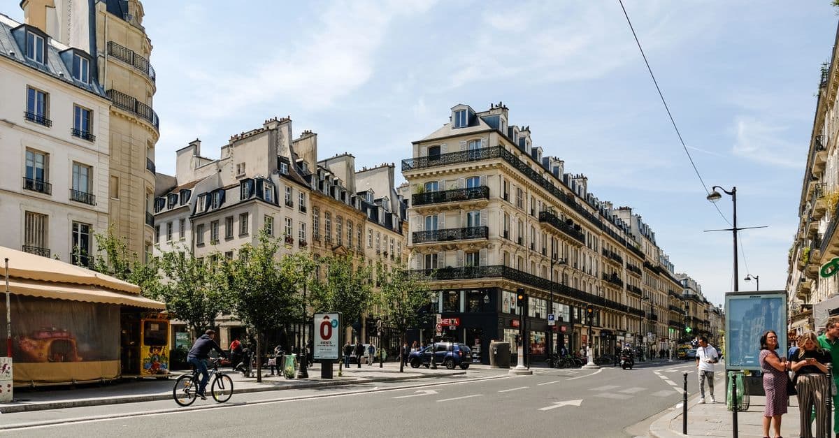 Turista connesso con il telefono sulle strade di Parigi durante il Tour de France 2025.