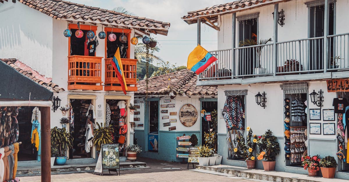 Calle colombiana con tiendas coloridas y decoraciones típicas que invitan a descubrir la mejor época para volar