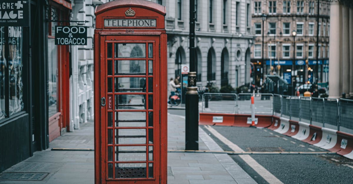 Bright red London telephone booth on a cobbled street, a timeless icon for travellers choosing a flip phone abroad.