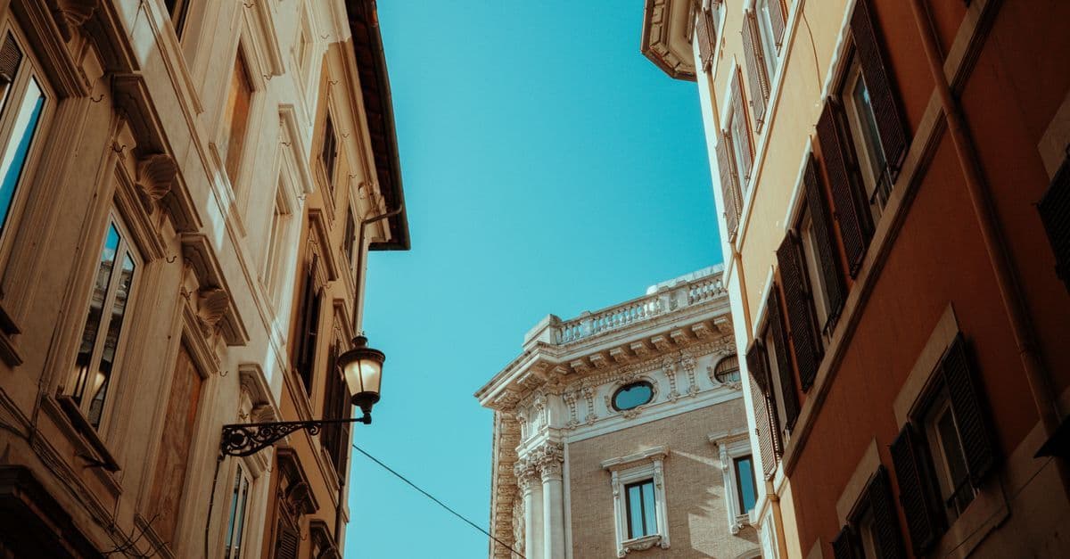 Rua histórica europeia com edifícios centenários e céu azul claro durante a alta temporada de verão na Europa