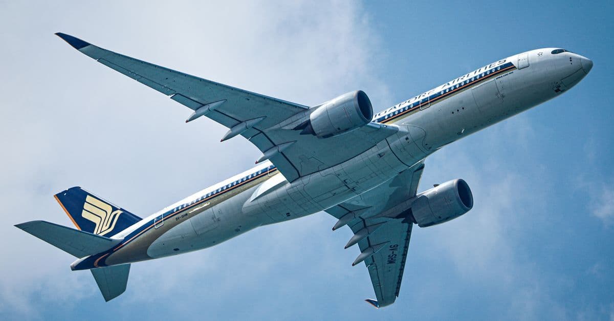 Commercial airliner viewed from below, representing the best time to book a Sydney to Singapore flight.