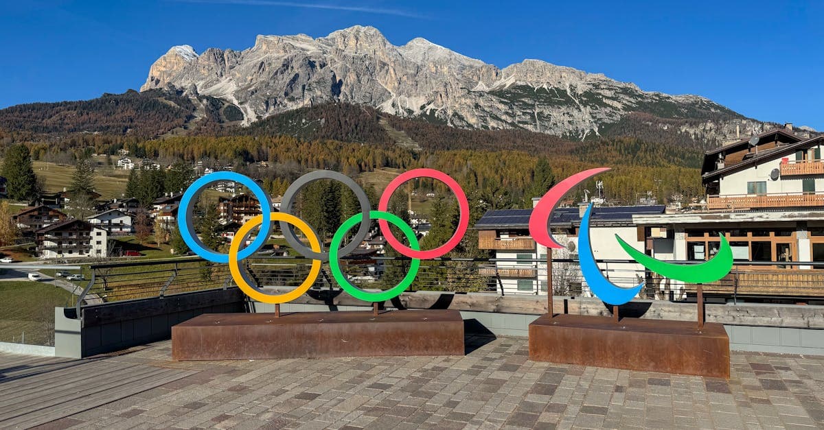 코르티나담페초 이탈리아 알프스를 배경으로 한 2026 년 동계 올림픽 알파인 스키 올림픽과 패럴림픽 상징이 설경 속에 웅장하게 서 있다
