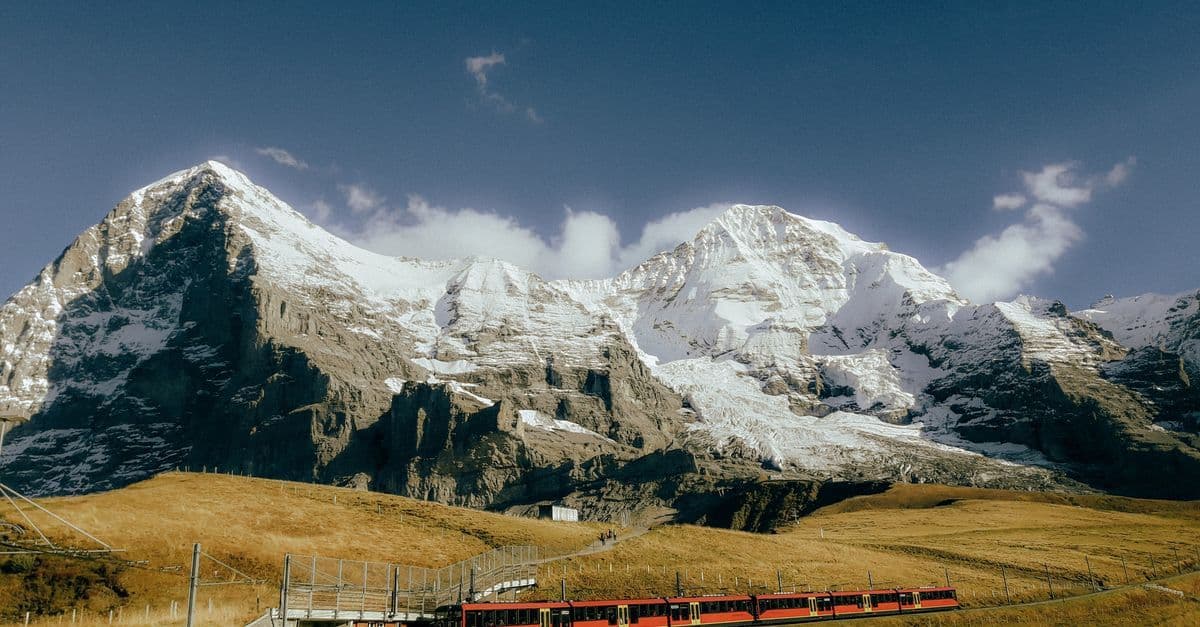 Roter Zug der Jungfraubahn fährt durch verschneite Schweizer Alpen bekannt als Top of Europe