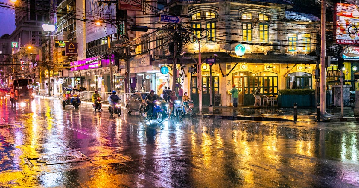 Vie nocturne de Bangkok par soirée pluvieuse avec rues animées et lumières néon illustrant la météo thaïlande