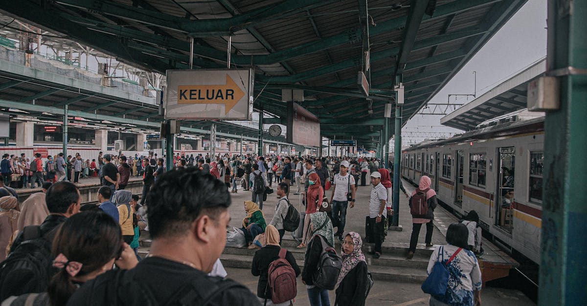 Suasana ramai peron stasiun kereta Indonesia dengan beragam penumpang, tetap terhubung saat darurat di luar negeri.