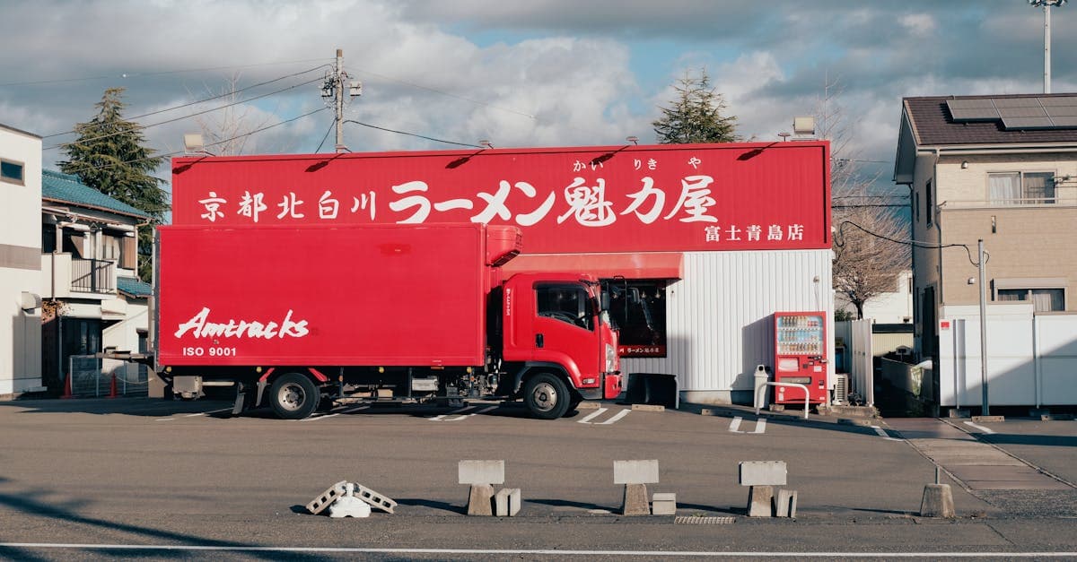 北海道のラーメン店前に停まる赤い配達トラック、味噌・醤油・塩の三大スタイルを巡る旅を象徴する光景