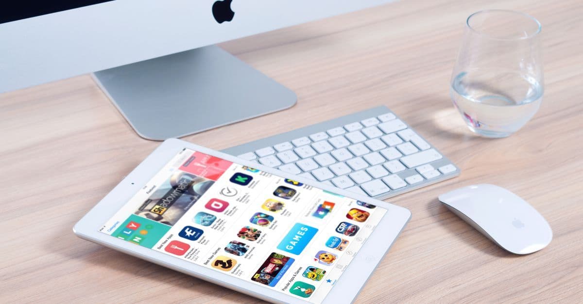 iMac en iPad met app-overzicht in een moderne thuiskantooropstelling voor de app store.