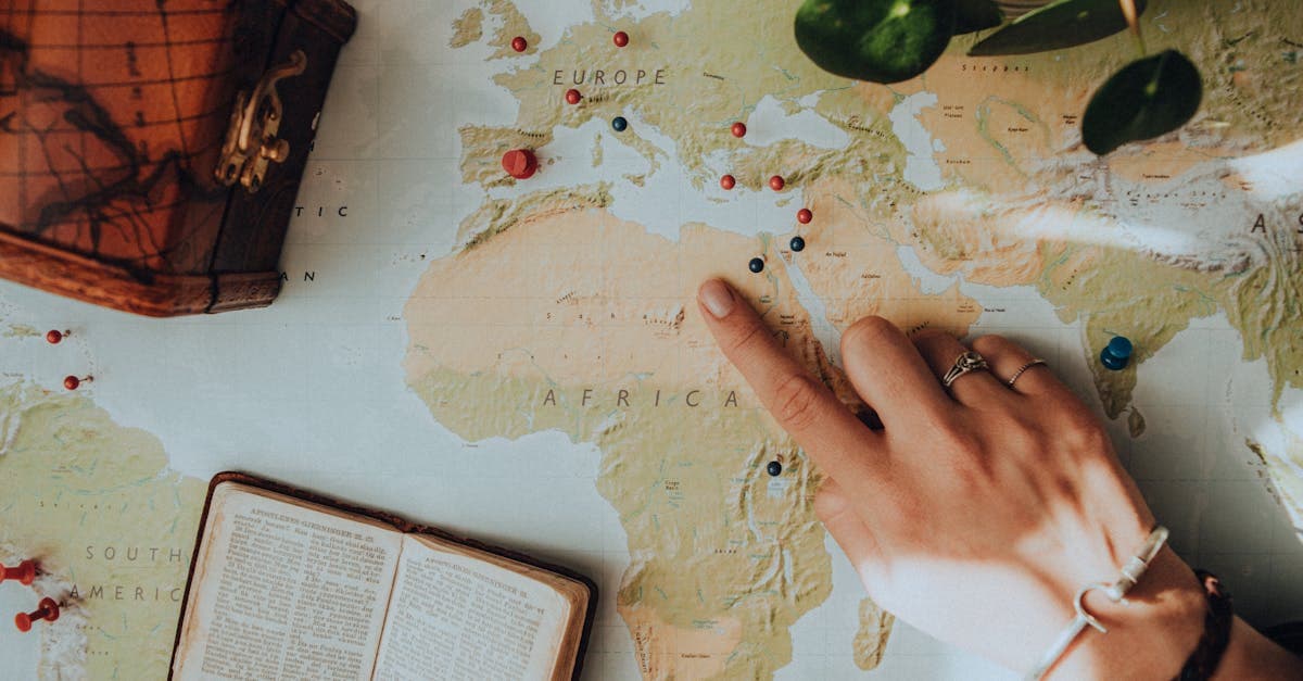 Bàn tay chỉ vào bản đồ cùng đồ dùng du lịch, minh họa khái niệm itinerary một cách trực quan.