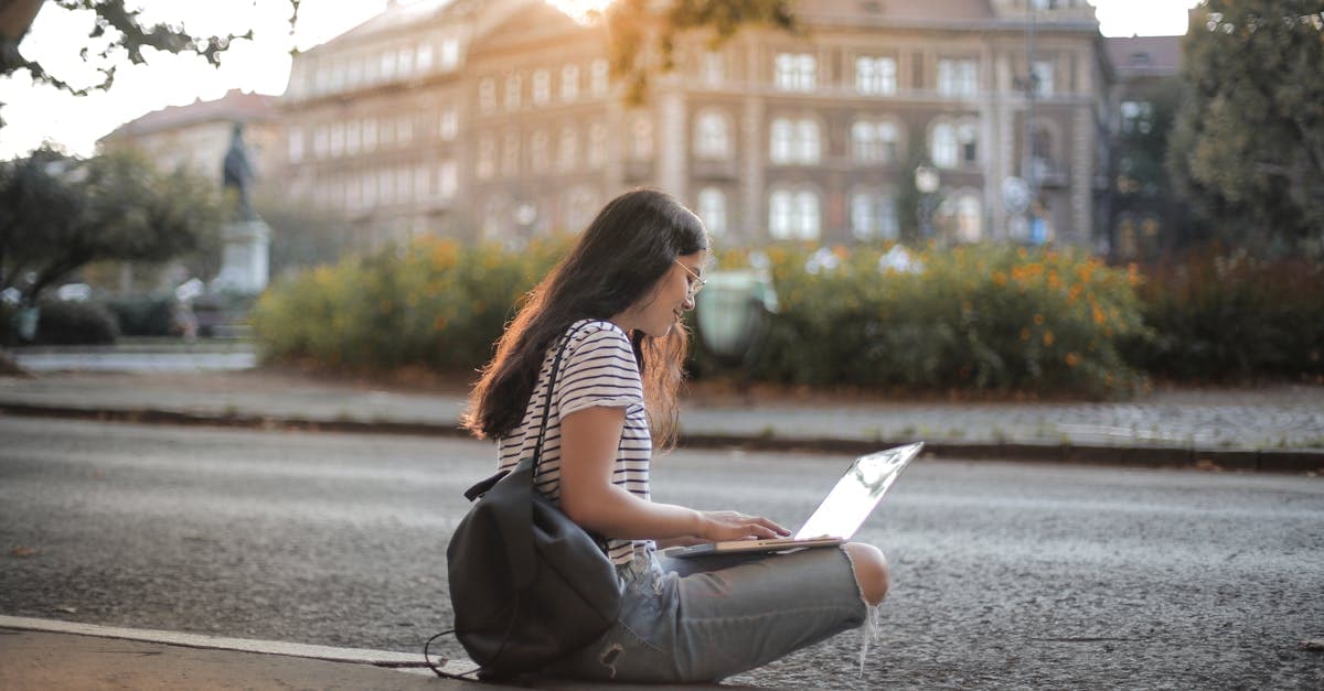 Perempuan muda menggunakan laptop di area perkotaan untuk memulai karier kerja remote luar negeri