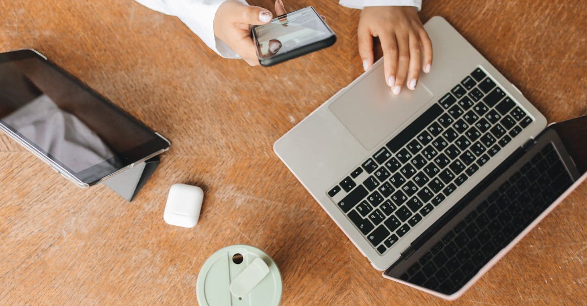 Vista cenital de un escritorio con portátil, tablet y móvil conectados simultáneamente al mismo wifi portatil de viaje