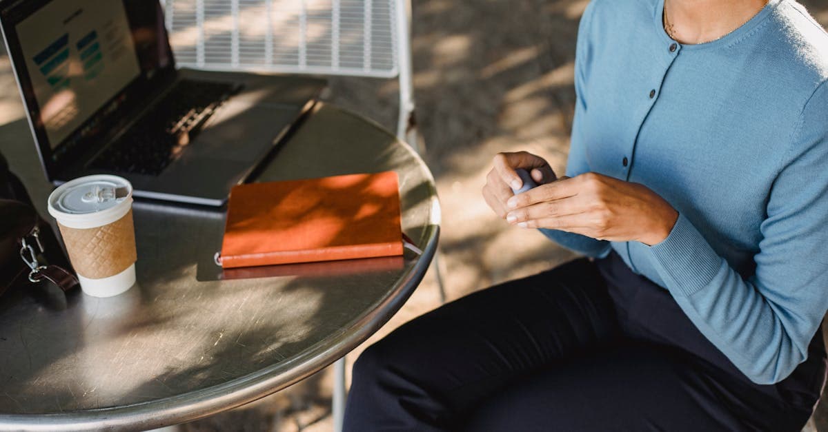 Kvinna arbetar vid utomhusbord på laptop med kaffe och wifi hotspot utomlands.