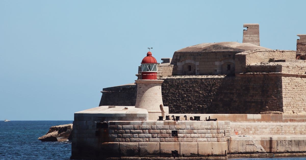 Opvallende vuurtoren naast eeuwenoude fortificaties aan de kust van Valletta in Malta