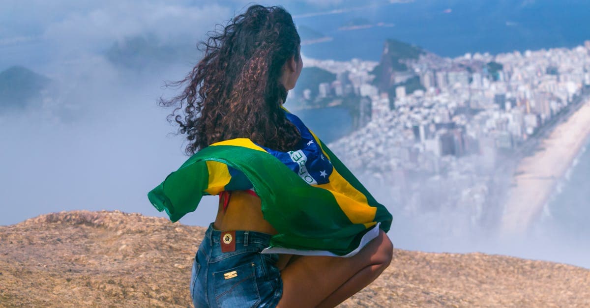 Mulher aprecia a vista panorâmica do Rio de Janeiro segurando a bandeira brasileira, comparando custo de roaming e eSIM