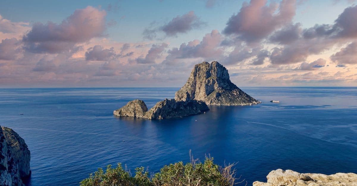 Malerisches Meerespanorama mit felsiger Insel im Sonnenuntergang – die schönsten Orte auf Sardinien entdecken.