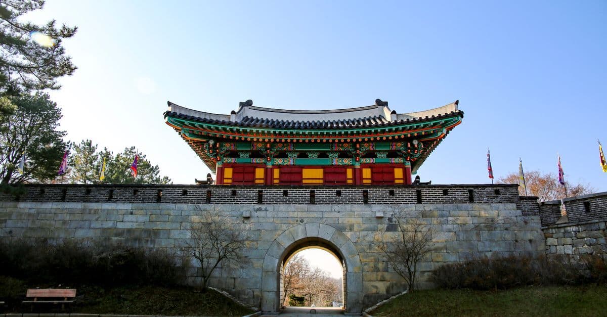 인천의 전통 한국 성문 앞에서 해외 출장 중에도 구글 슬라이드로 업무를 이어가는 비즈니스 여행자