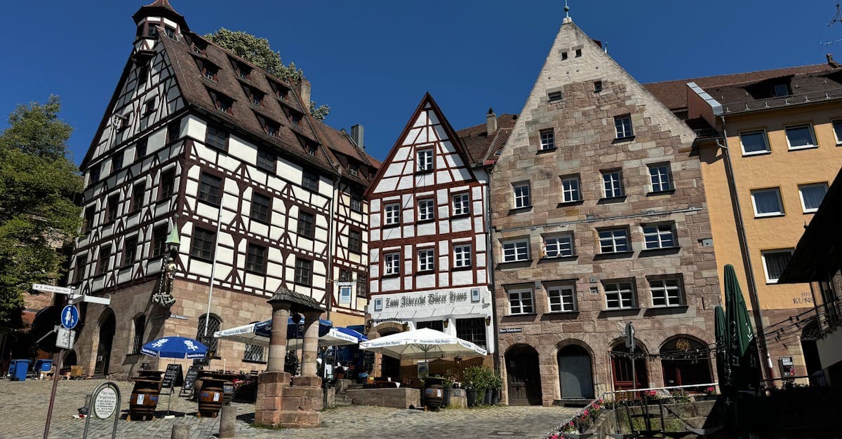 Historic half-timbered buildings in Nuremberg's old town under clear blue skies, capturing medieval charm.