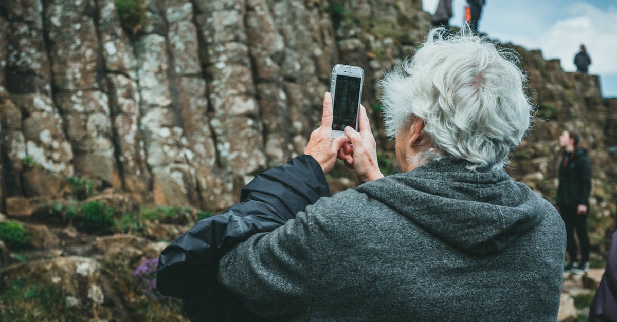 Traveler photographing Irish rocky landscape while staying connected with a travel eSIM in Ireland