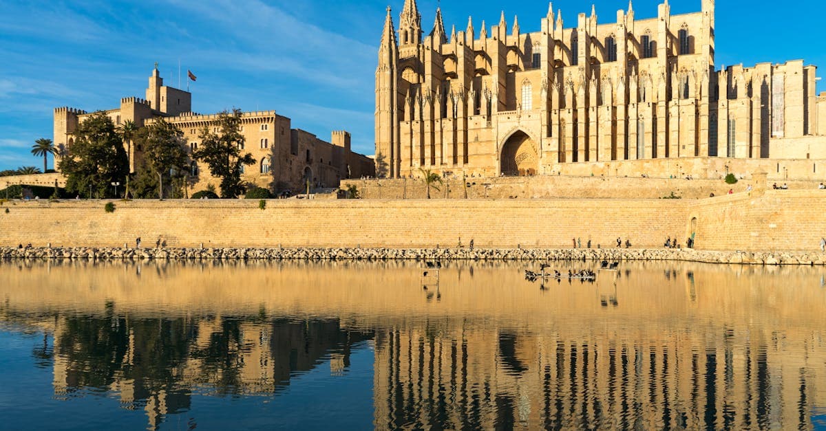 Gotische Palma-kathedraal weerspiegelt in het water onder een strakblauwe lucht in september op Mallorca.