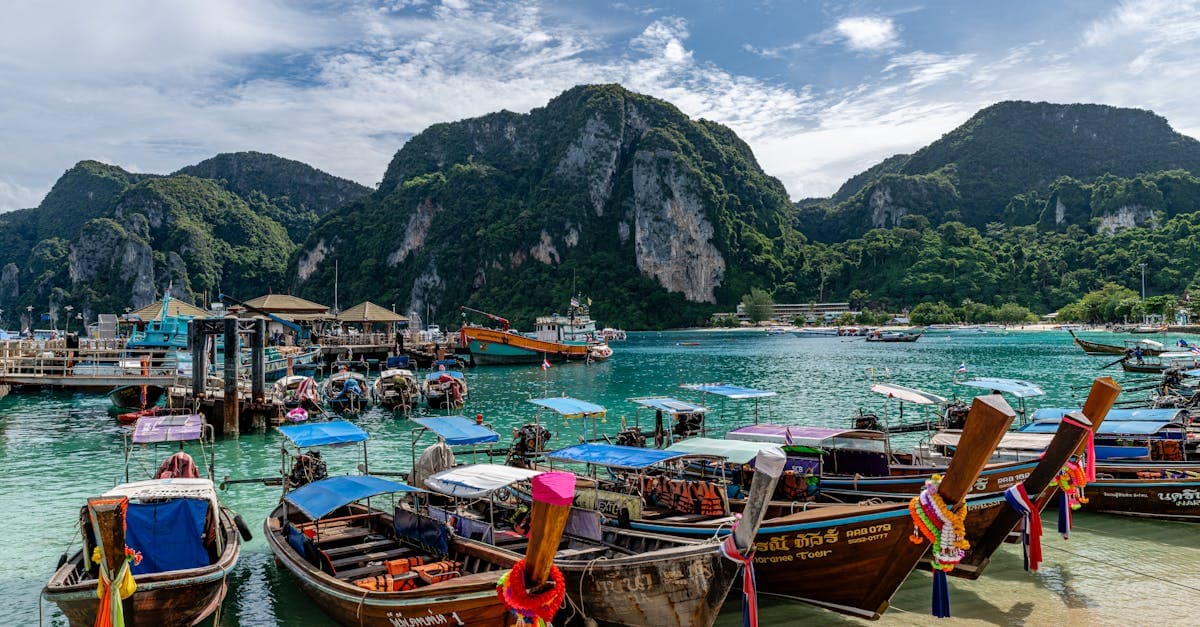 Colourful traditional boats anchored in a sheltered Phuket bay, ideal during the best months for a Thailand holiday.