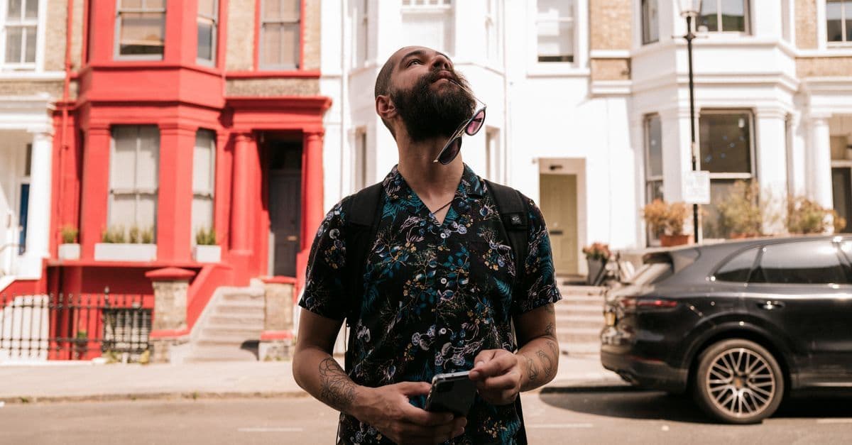 Man in sunglasses using his smartphone on a London street, travelling abroad with a SMARTY SIM