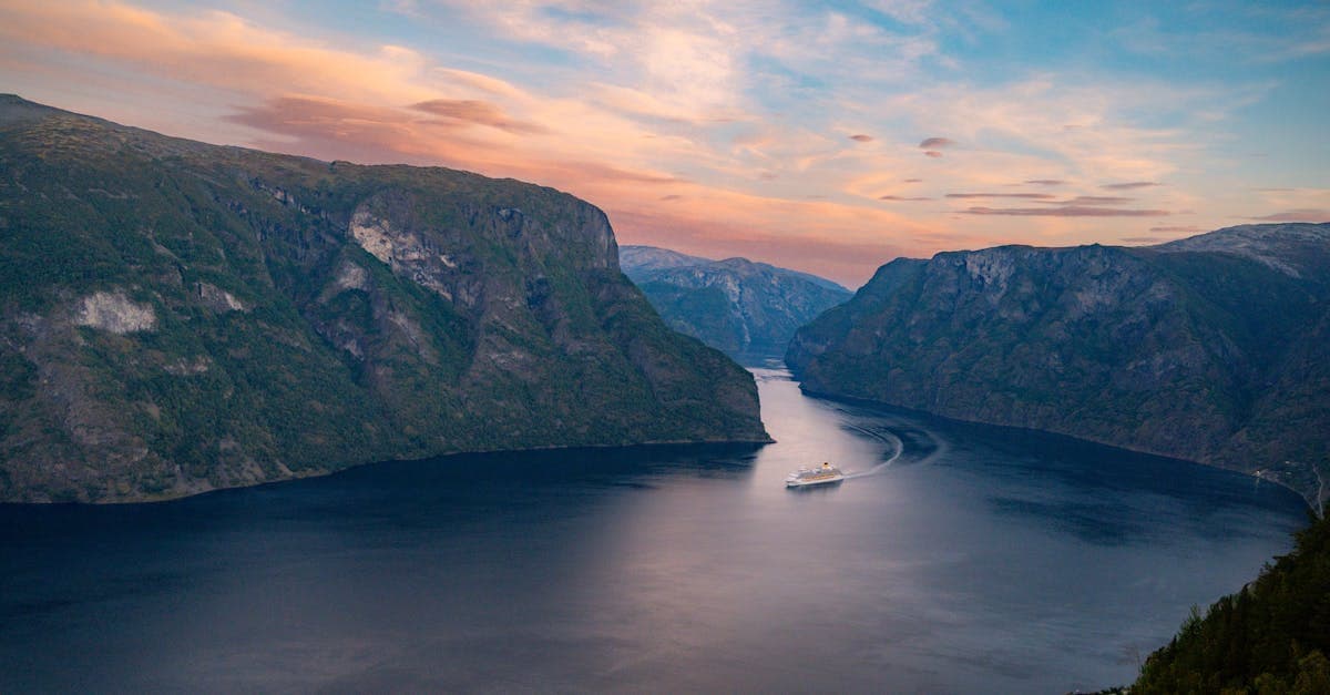 Cruise ship departing from a UK port bound for a norwegian fjords cruise at golden-hour sunset.