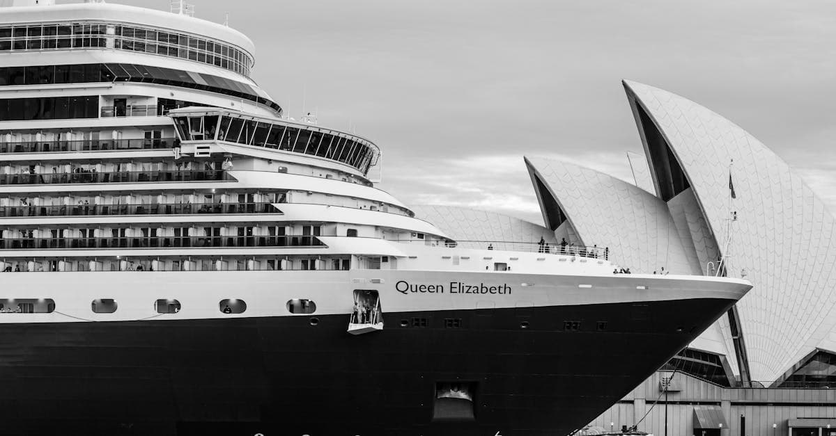 Queen Elizabeth cruise ship anchored beside Sydney Opera House, ready to depart on a cruise to New Zealand from Sydney.
