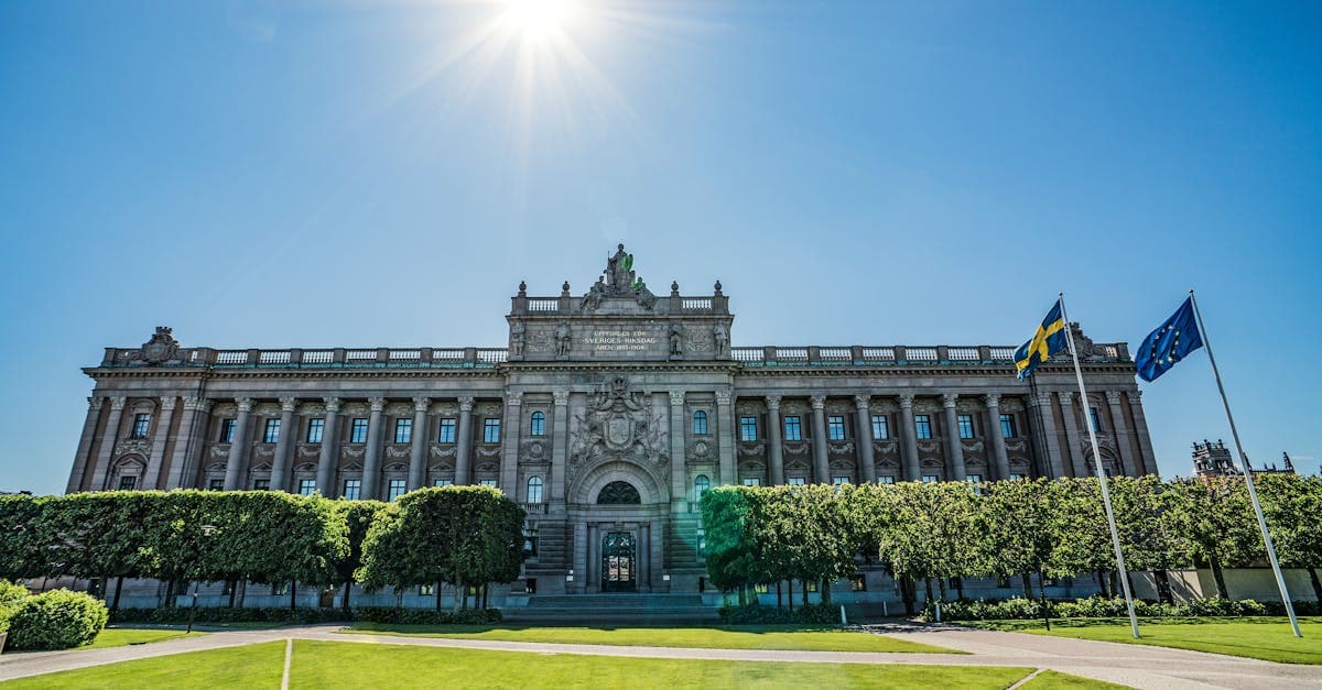 Riksdagshuset med svenska och EU-flaggor i solljus – EU-reglering gör dataroaming inom unionen gratis.